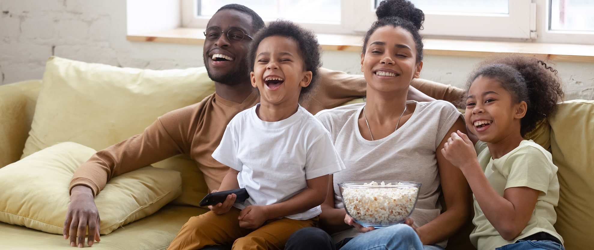 Family laughing together while eating popcorn